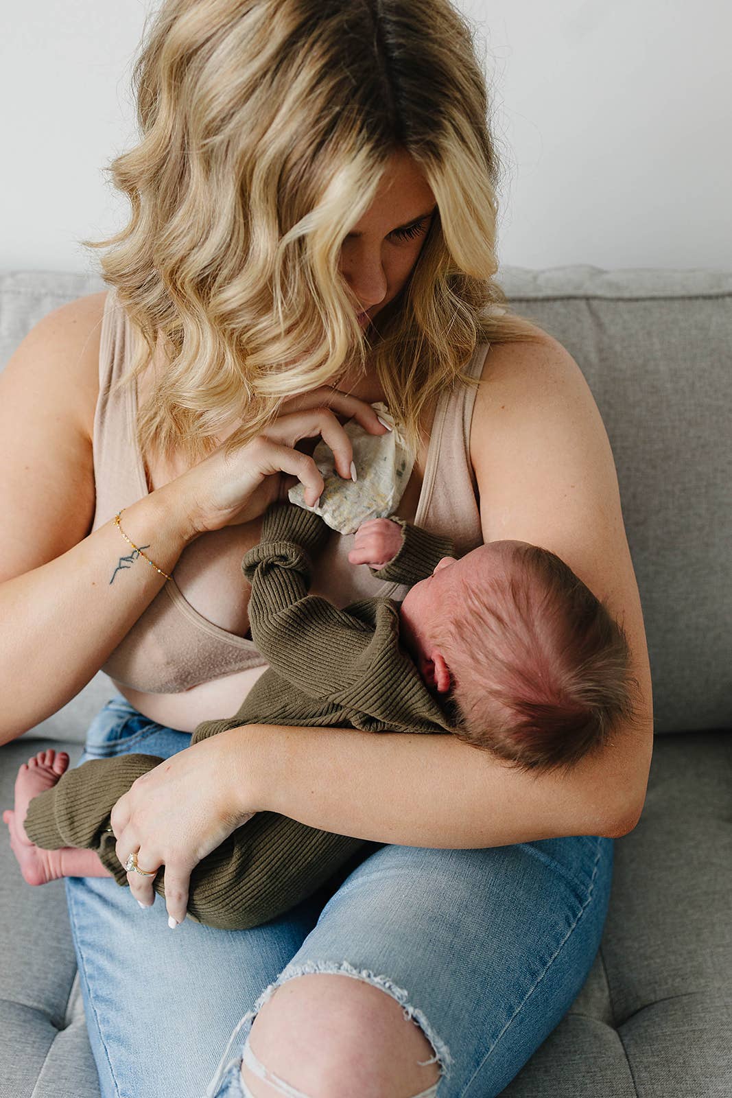 Woman breastfeeding a baby on a couch