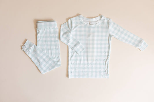 Children's light blue checkered pajama set on a beige background