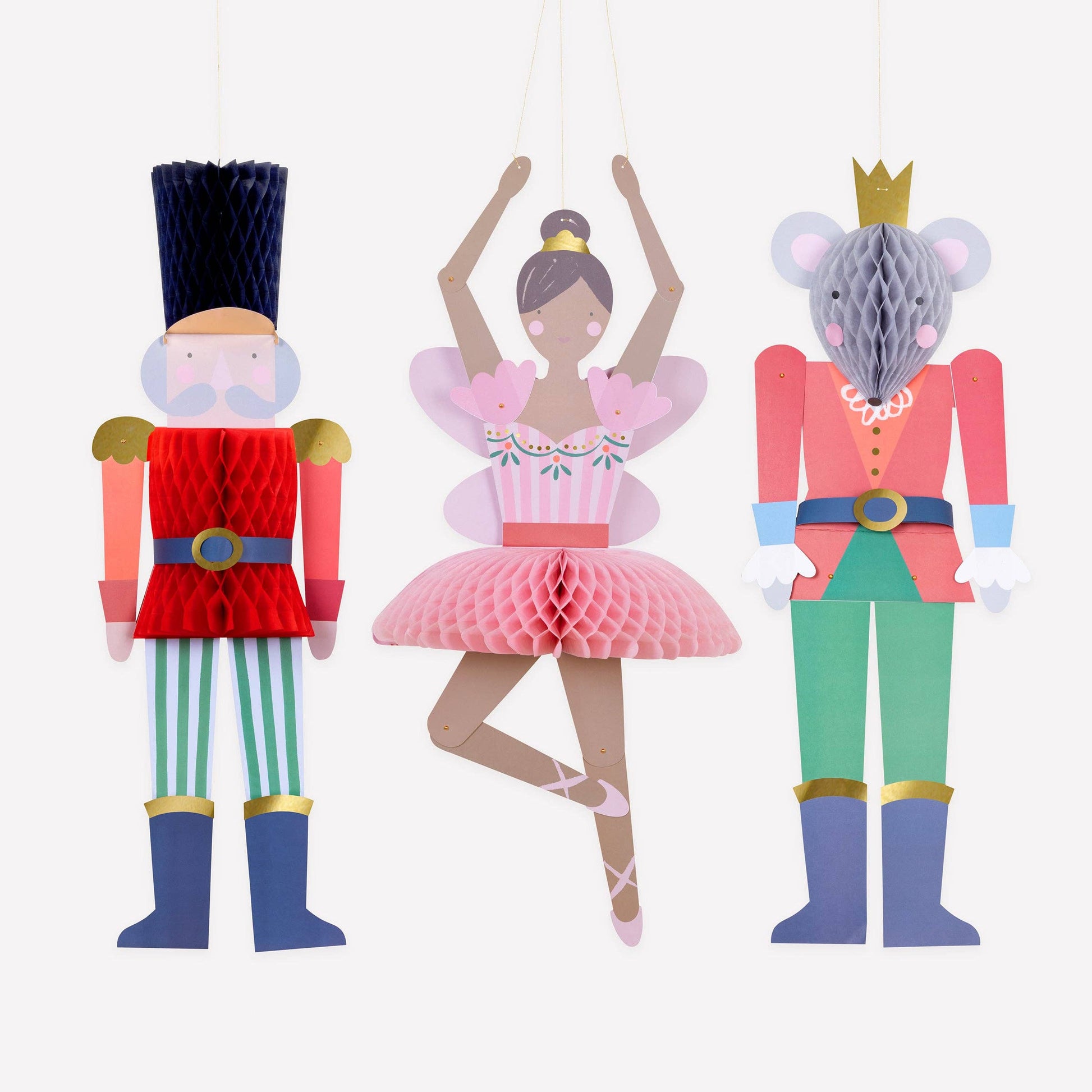 Decorative paper cutouts of a nutcracker, ballerina, and mouse king on a white background