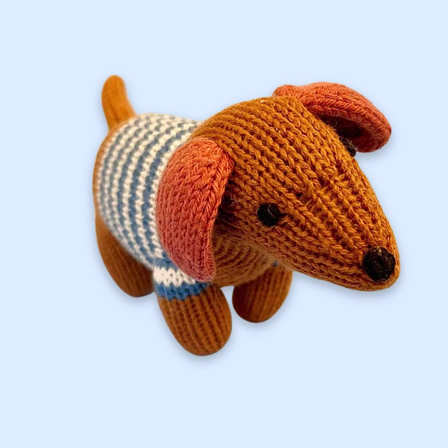 Knitted dog toy with a striped sweater on a light blue background