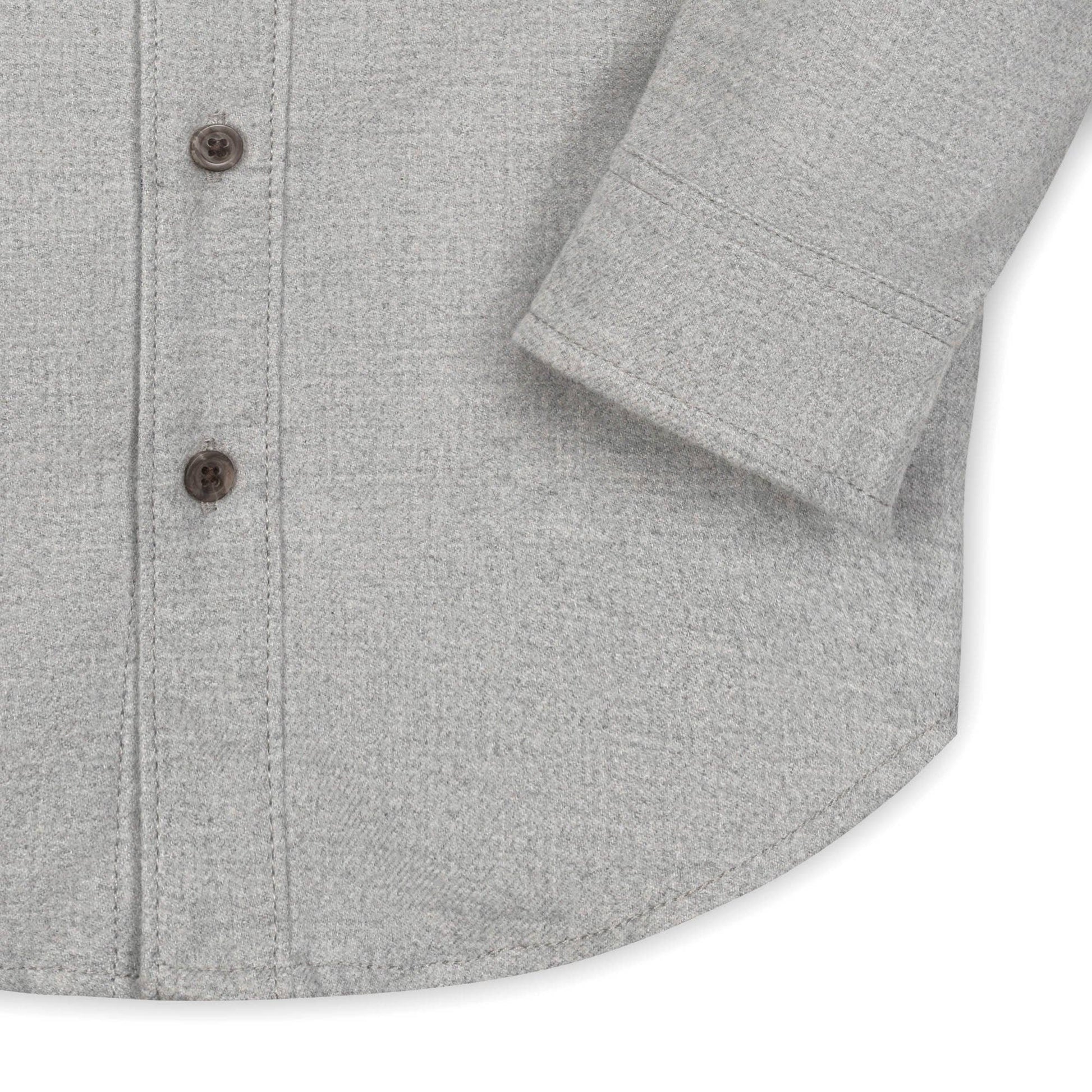 Close-up of a gray textured shirt with buttons on a white background