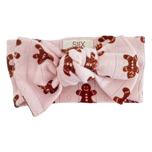 Baby headband with gingerbread pattern and bow on a white background