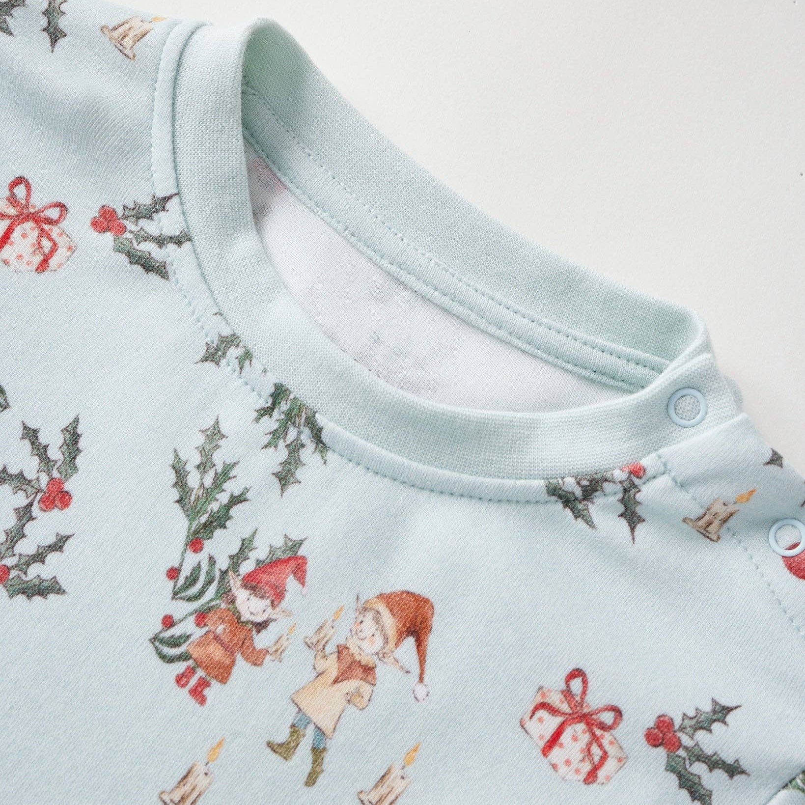 Baby onesie with Christmas-themed print on a light blue background