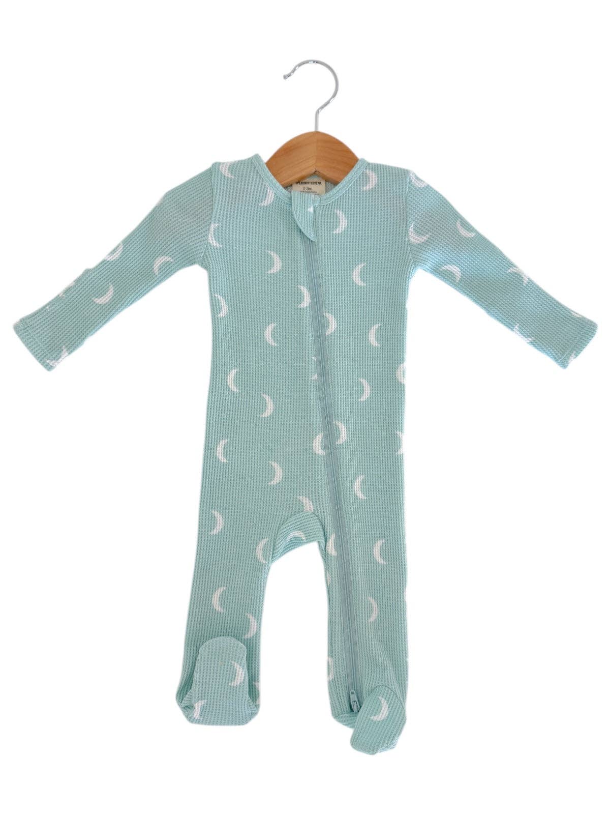 Baby onesie with moon pattern on a hanger against a white background