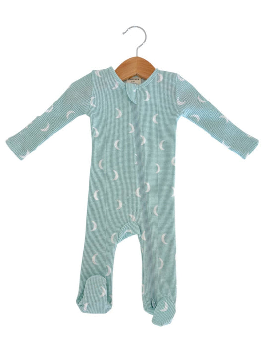 Baby onesie with moon pattern on a hanger against a white background
