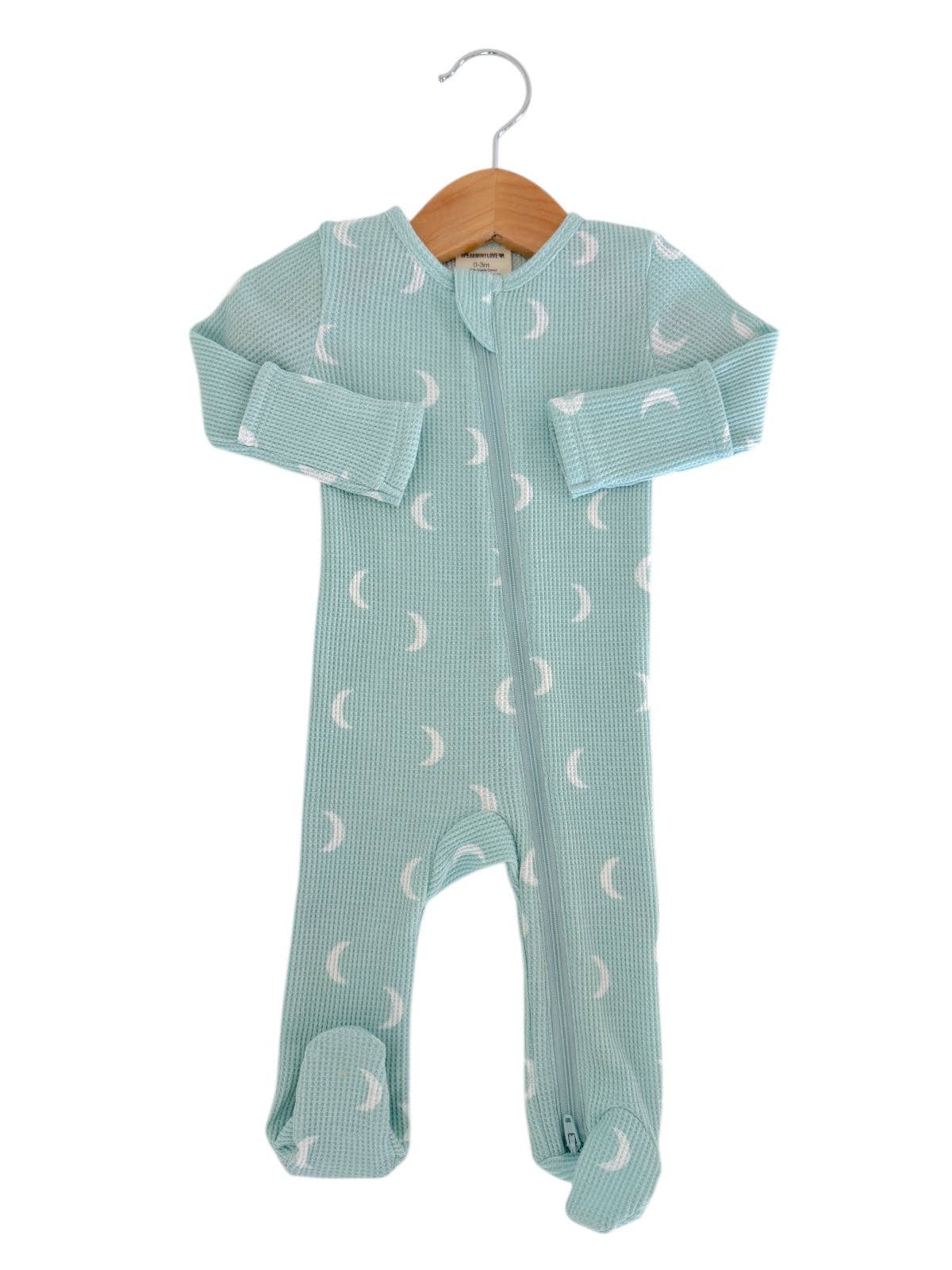 Baby onesie with moon pattern on a hanger against a white background