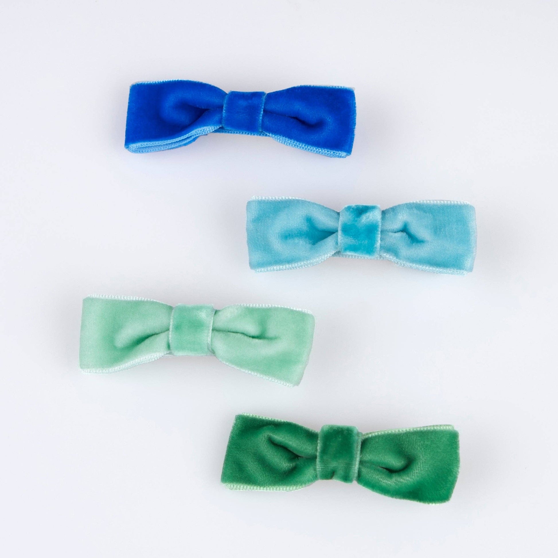 Four colorful velvet hair bows on a white background