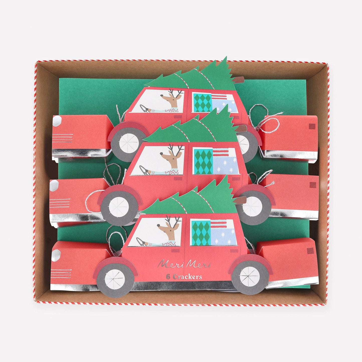 Box of red car-shaped Christmas cards with green trees and deer on a white background