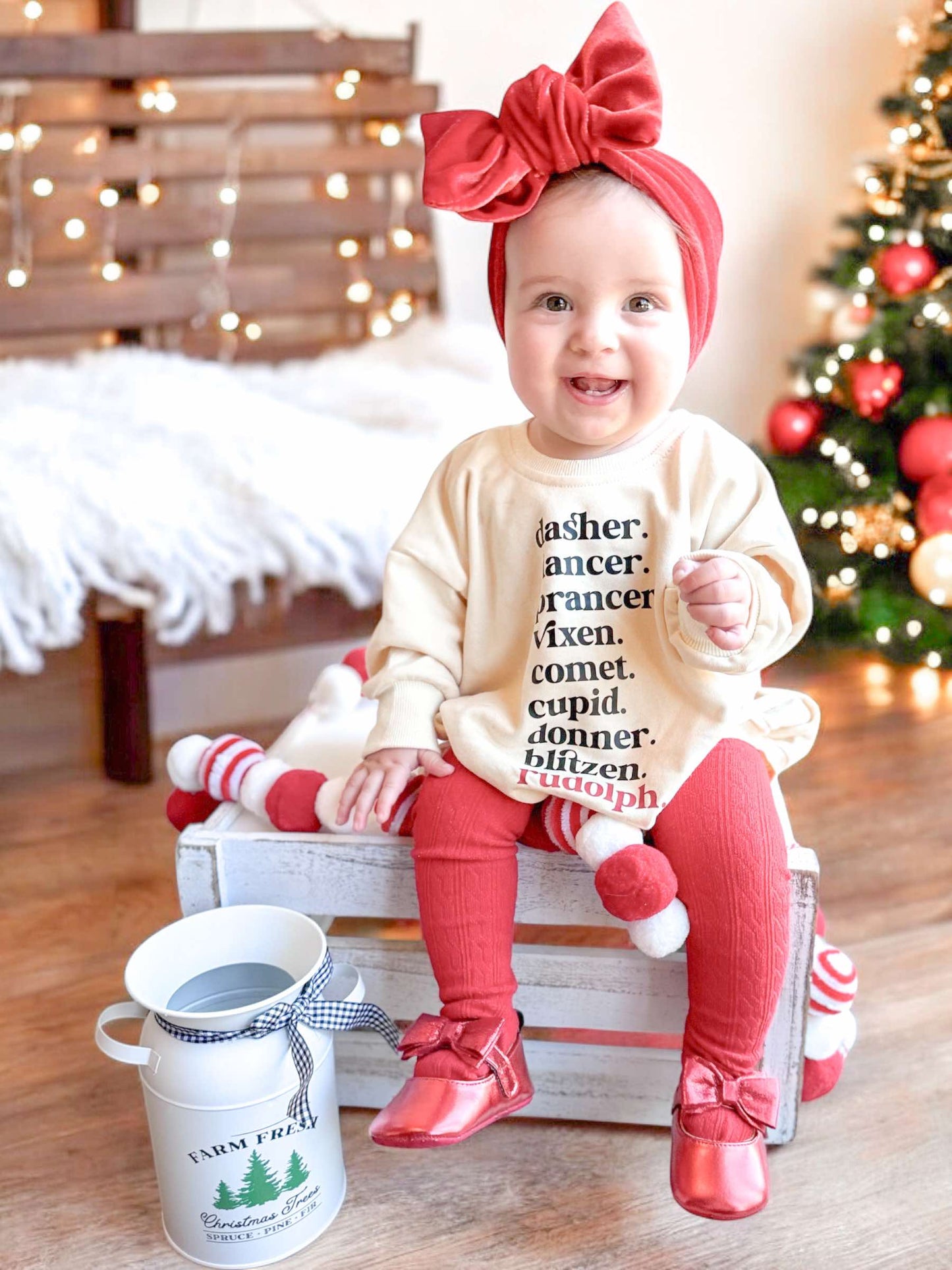 Baby in festive outfit with Christmas decorations in the background