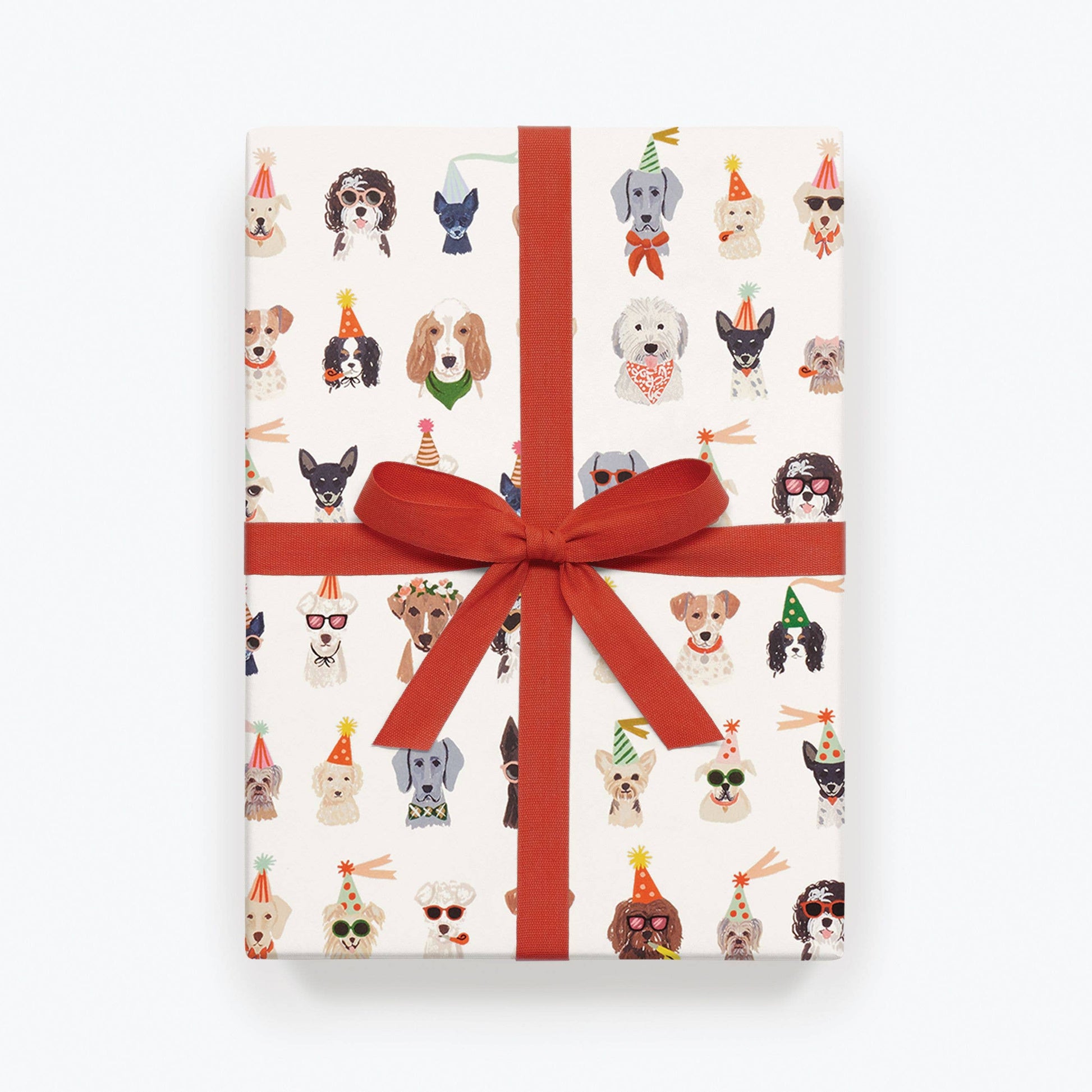 Gift box with dog illustrations and a red ribbon on a white background