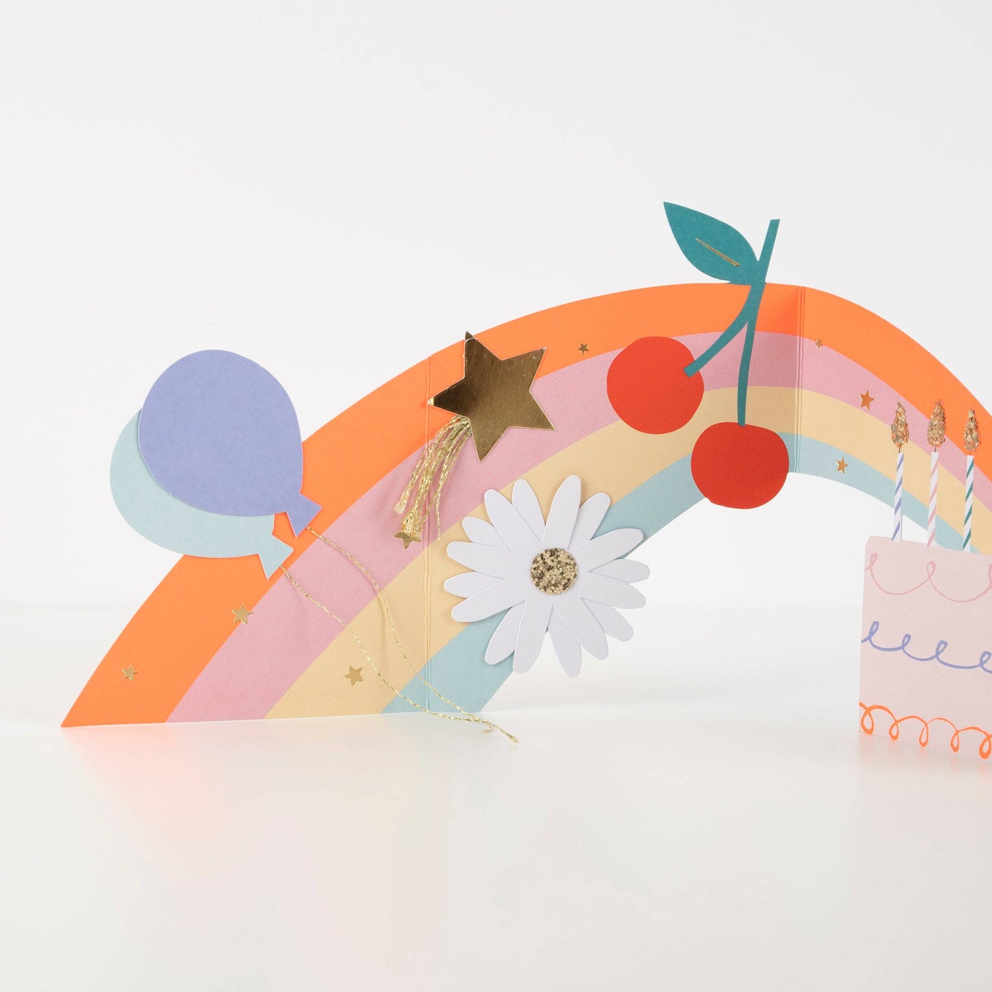 Colorful paper craft with rainbow, flowers, and cherries on a white background