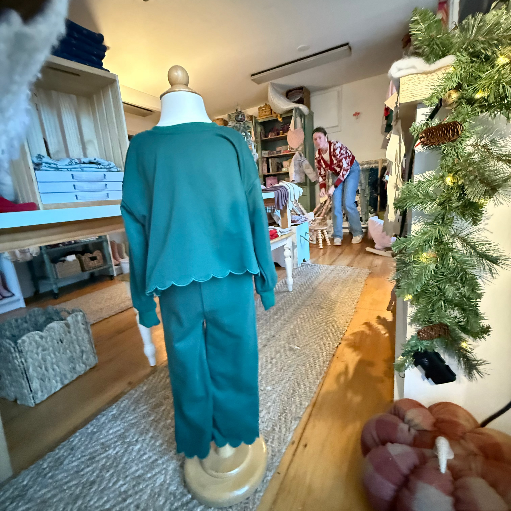 Pine green outfit on a mannequin in a room with a Christmas tree and decorations.