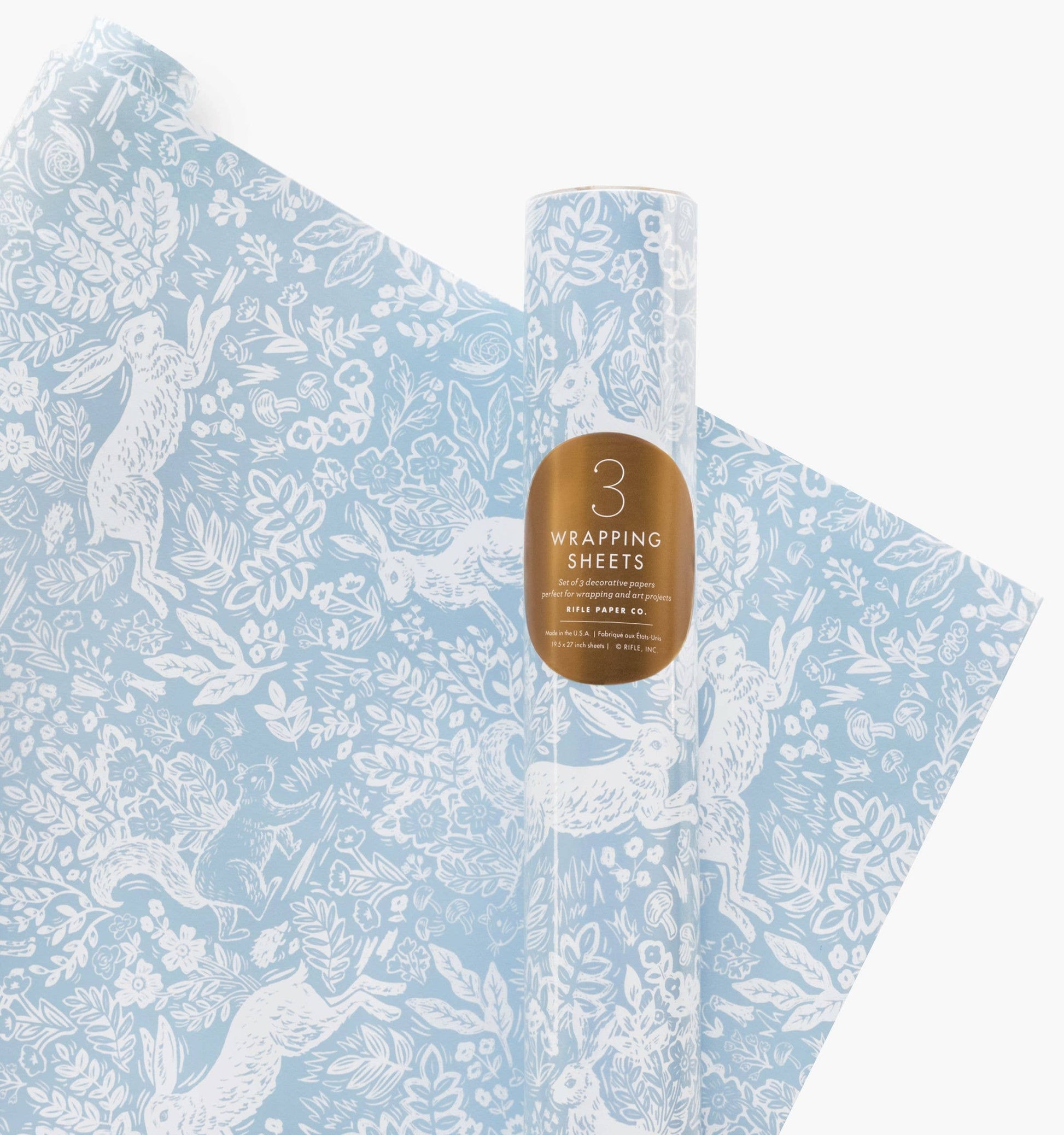 Roll of blue wrapping paper with white animal designs and a bottle of water on a white background