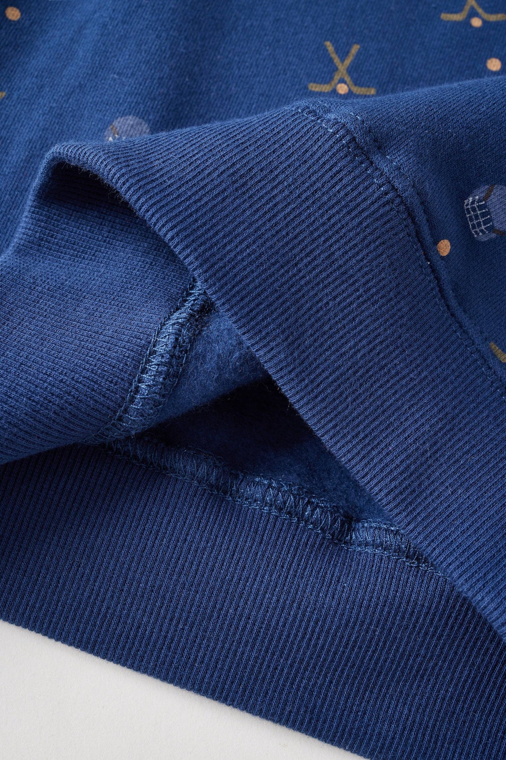 Close-up of a blue fabric with embroidered patterns on a white background