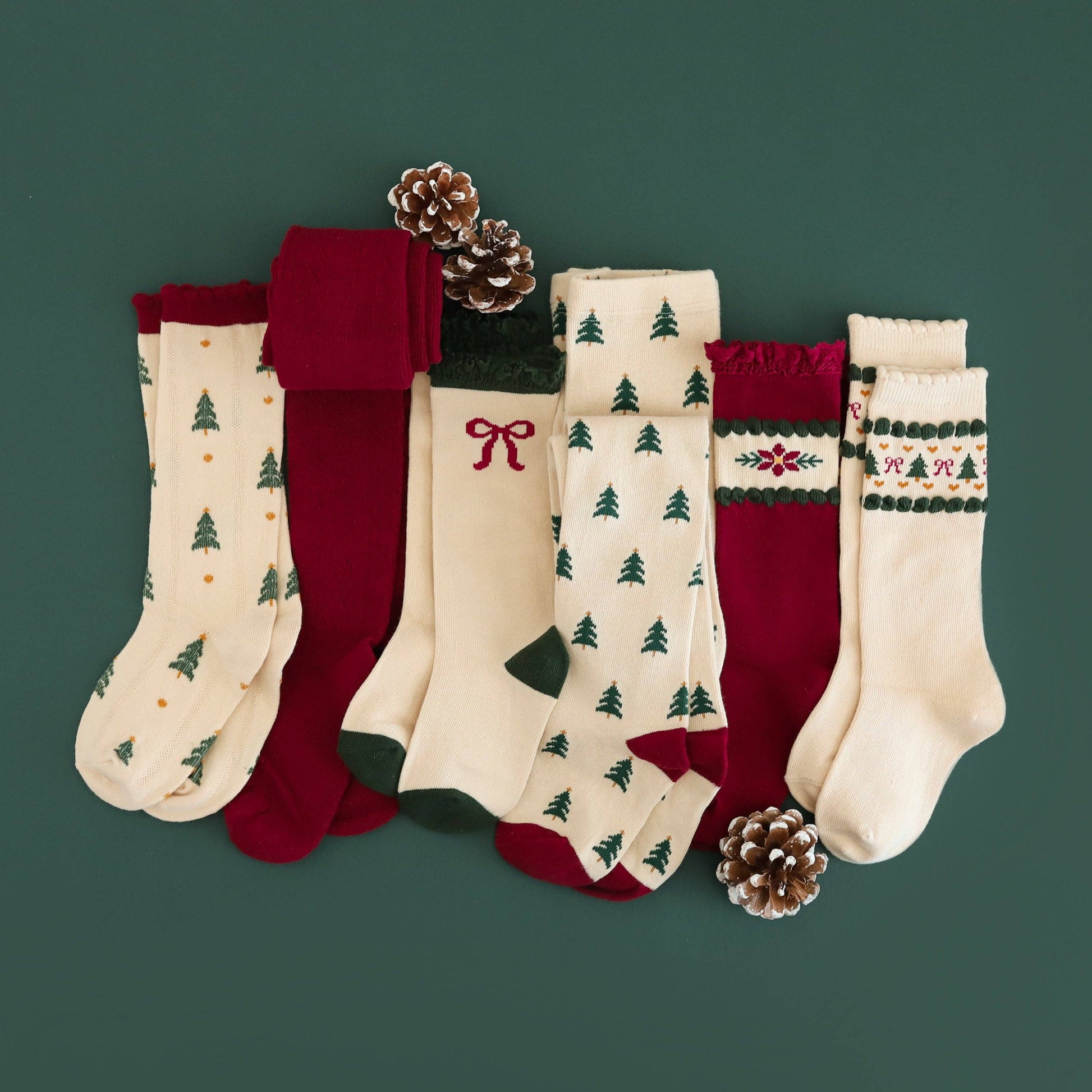 Set of Christmas-themed socks with tree and bow designs on a green background