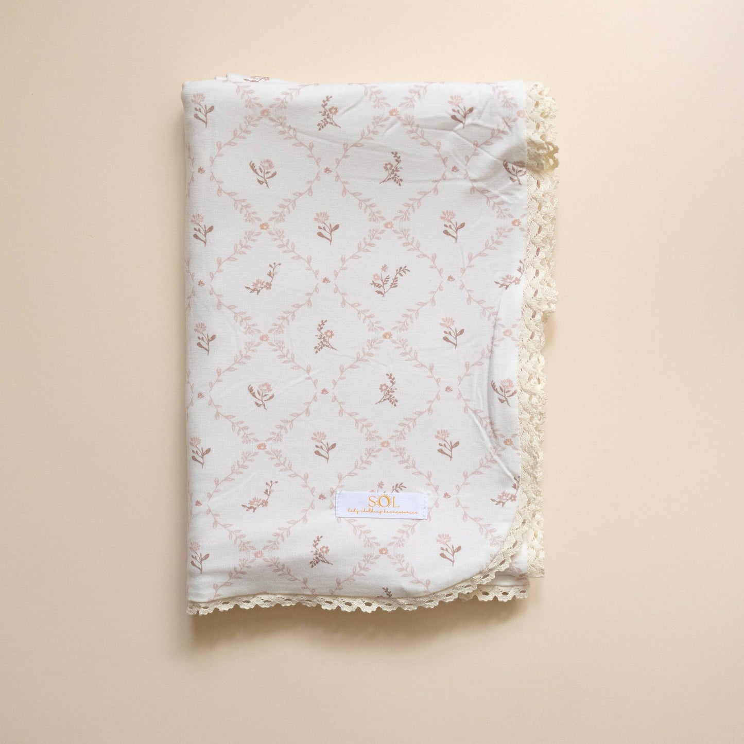 Floral patterned fabric with lace trim on a beige background