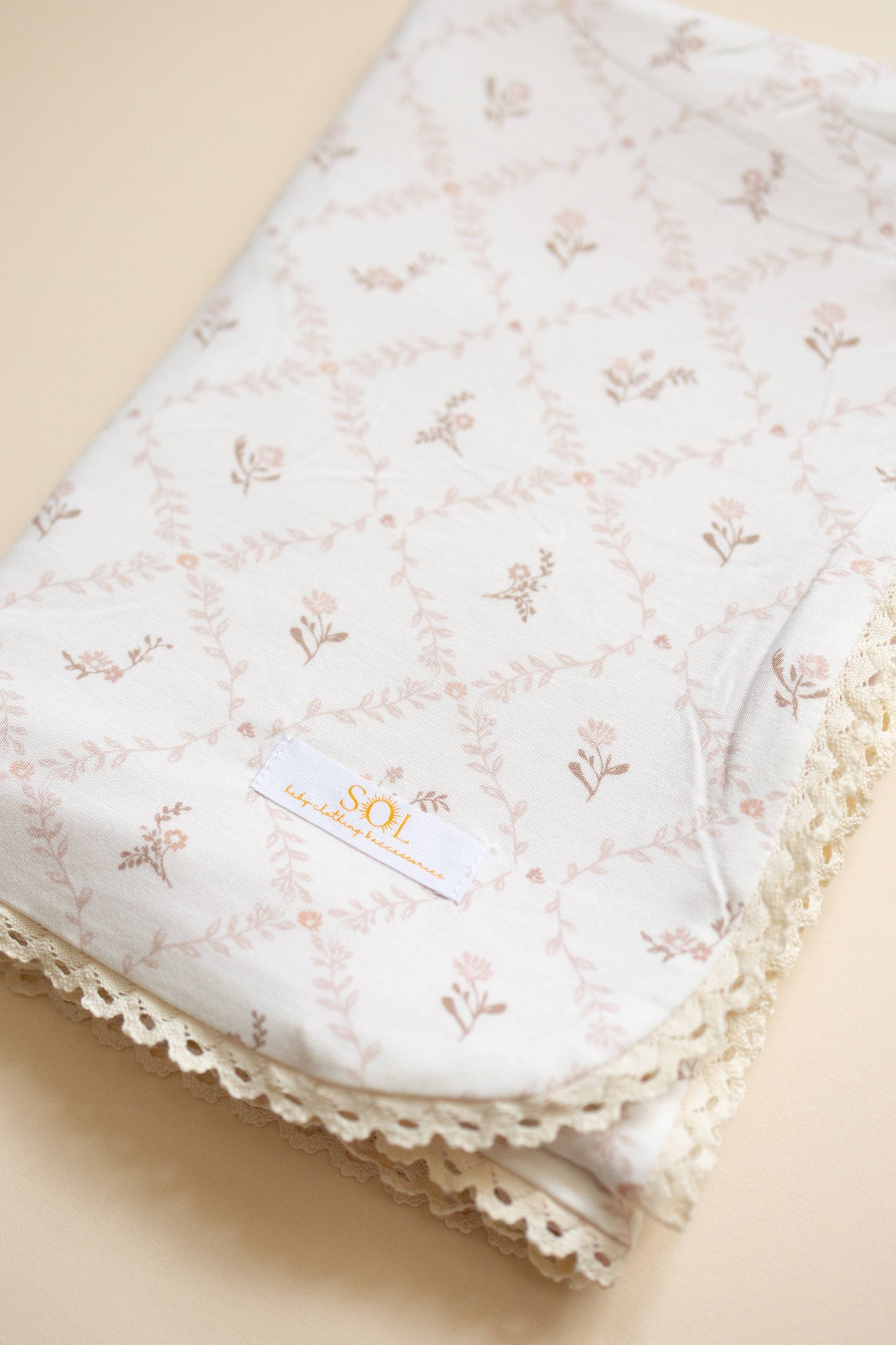 Floral-patterned fabric with lace trim on a beige background
