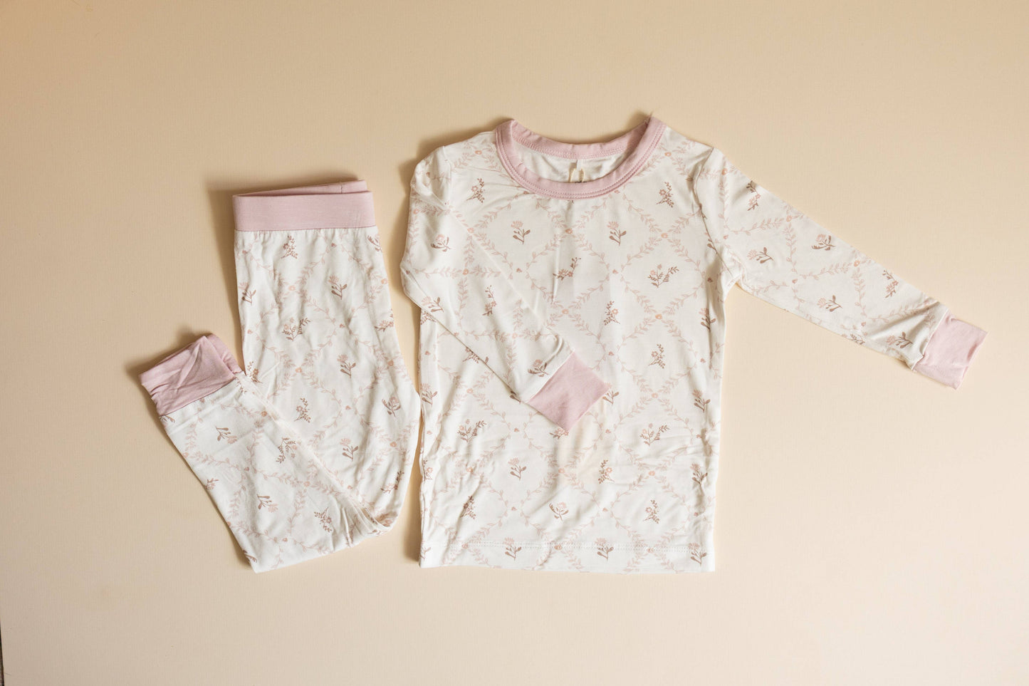 Children's pajama set with long-sleeve top and pants on a beige background