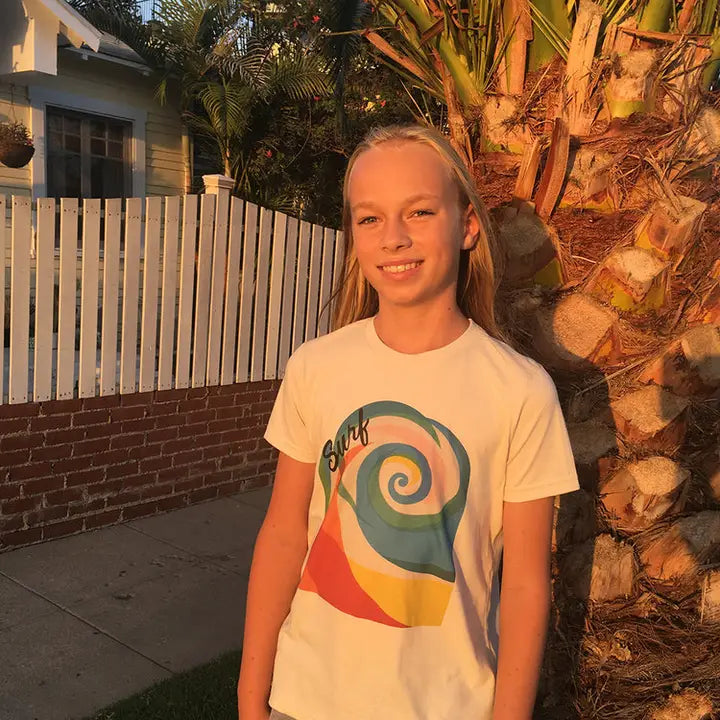 Young girl wearing a t-shirt with a colorful design in a backyard setting