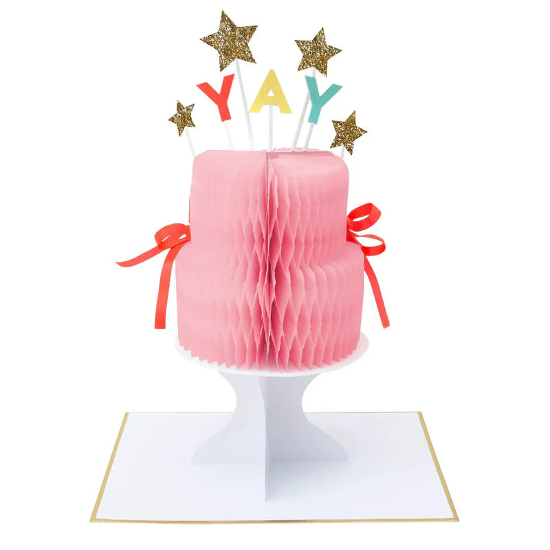 Pink paper cake with 'YAY' candles and star toppers on a white background