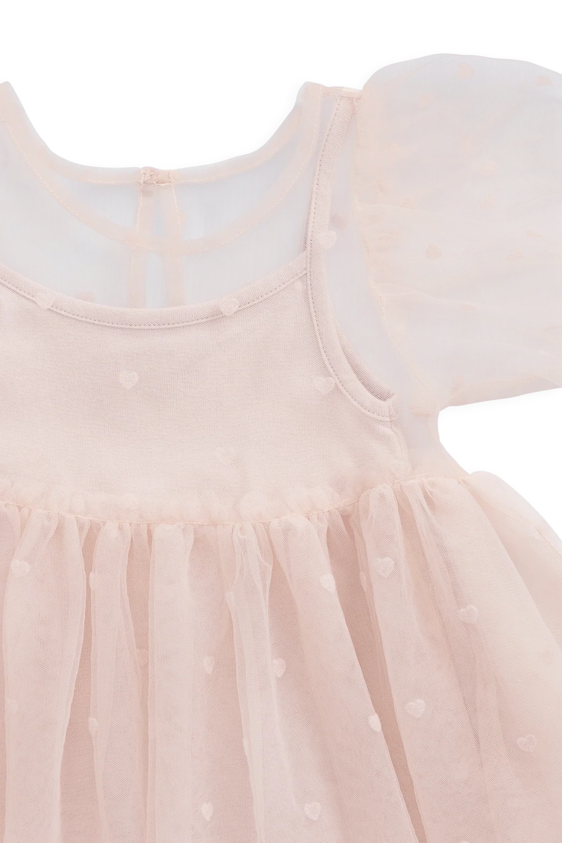 A close-up of a pale blush pink tulle dress with a sheer mesh yoke, thin shoulder straps, and small heart-shaped dots throughout, shown against a plain white background.