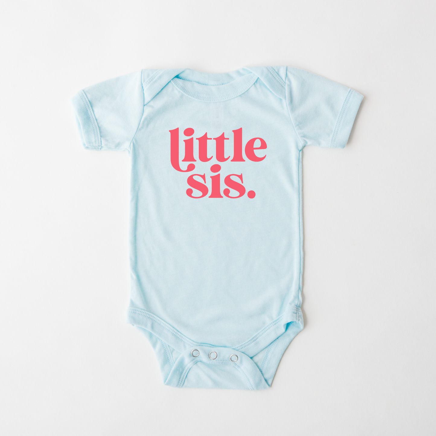Light blue baby onesie with 'little sis' text in pink on a white background