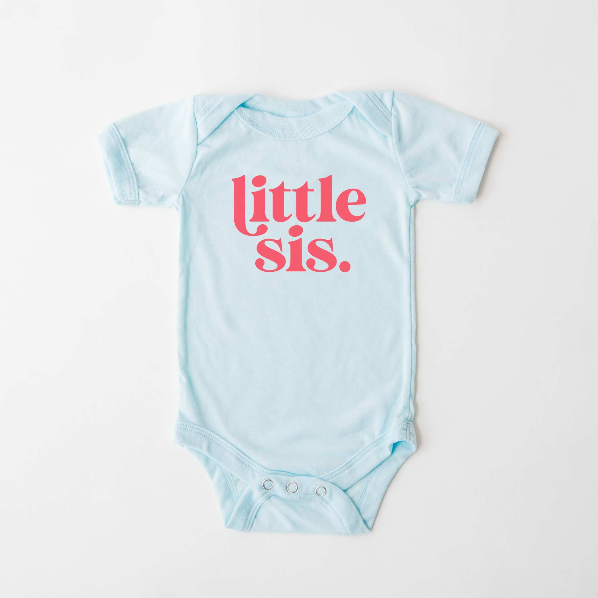 Light blue baby onesie with 'little sis' text in pink on a white background