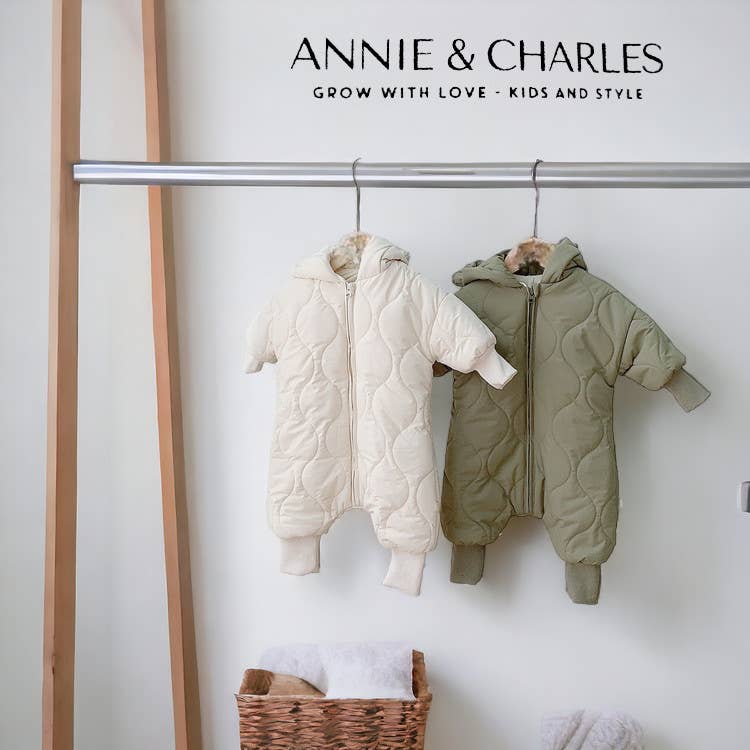 Two children's snowsuits hanging on a rack with 'Annie & Charles' branding.