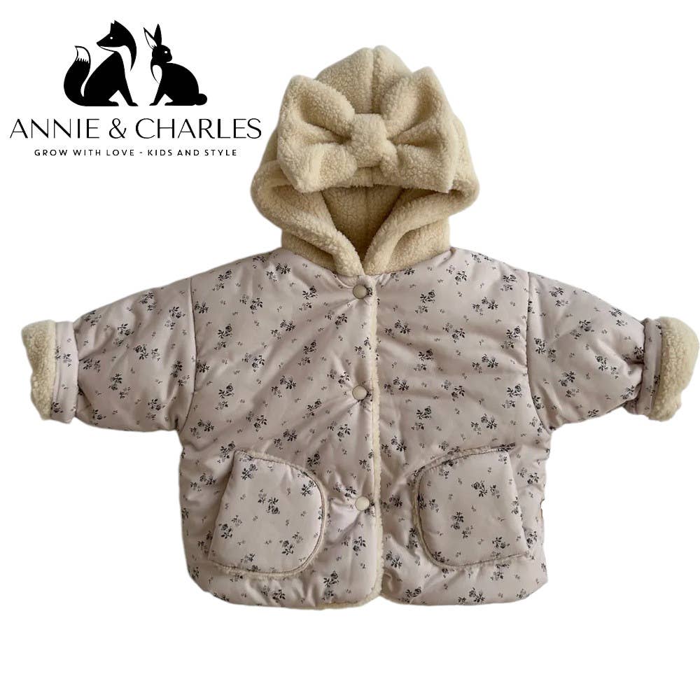 Children's puffer jacket with floral pattern and bow hood on a white background, featuring the Annie & Charles brand.
