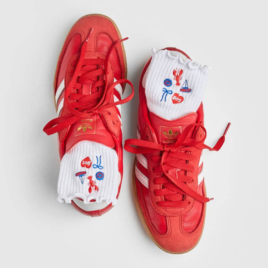Red sneakers with white soles on a light gray background