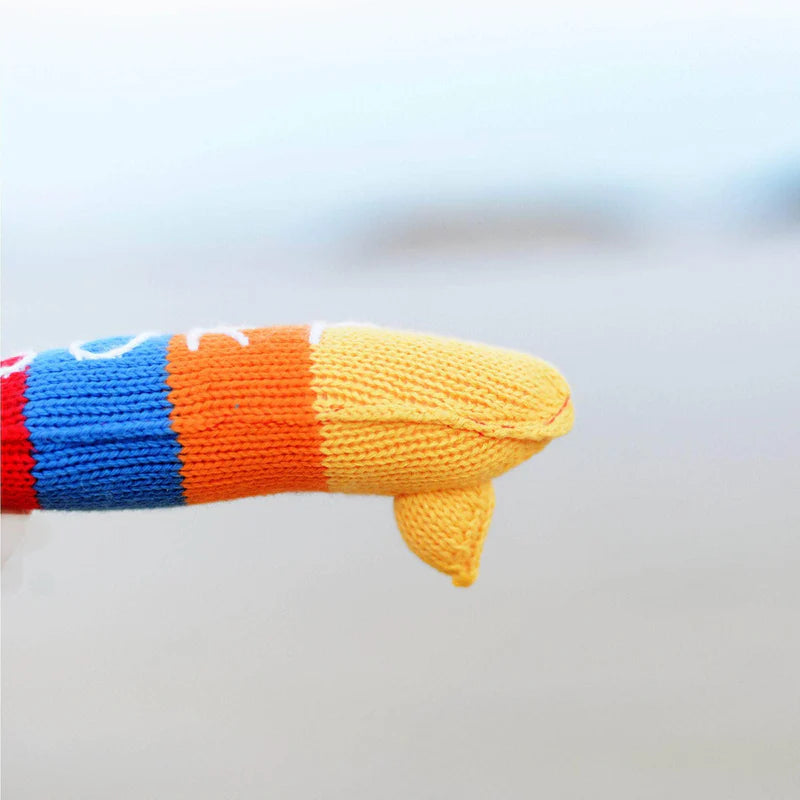 Colorful knitted surfboard rattle on a light gray background