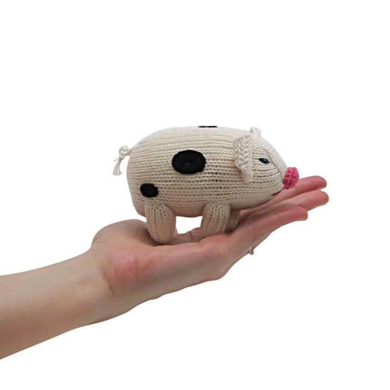 Hand holding a small knitted animal toy on a white background