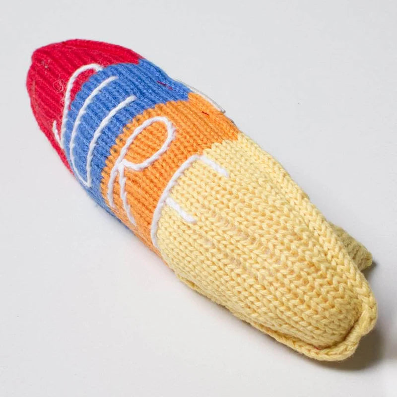 Colorful knitted toy resembling a surfboard on a light gray background